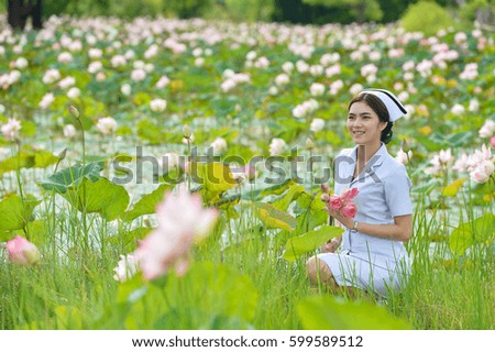 Young nurse portrait,beautiful woman in nurse suit portrait,nurse suit thailand,Asian nurse holding flower on lotus flower background,Thailand