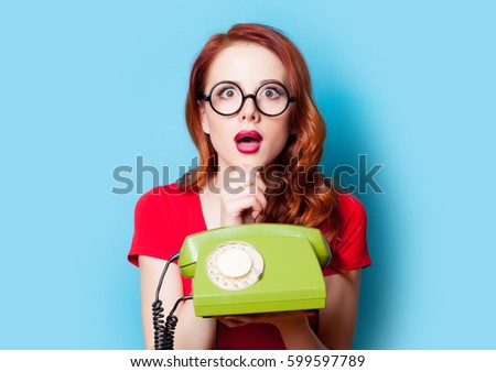 beautiful surprised young woman with retro phone on the wonderful blue background