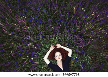 beautiful young woman lying and relaxing on the wonderful blooming lavender field