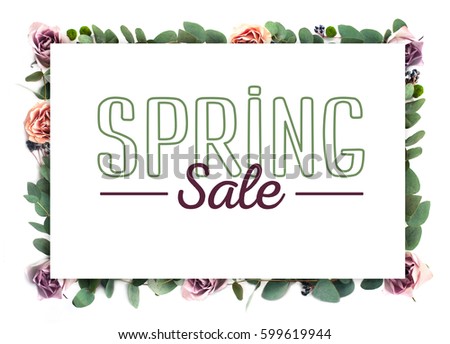 Creative flower frame. White paper on the background of roses flowers and eucalyptus with lettering “Spring sale”. A template for a poster, a brochure, a leaflet.