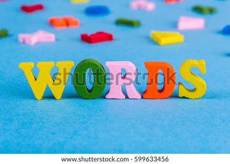 Word words made of colored wooden letters on a blue background
