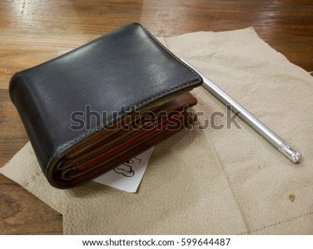 Soft tone of Money and crredit card in a leather wallet on wooden table background.

