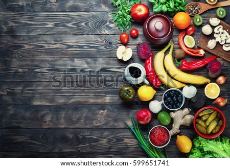 Vegetables and fruits on a dark rustic wooden table. Healthy vegetarian food. Royalty-Free Stock Photo #599651741