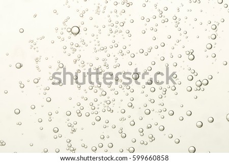 Many small fizz bubbles flows toward the surface Royalty-Free Stock Photo #599660858