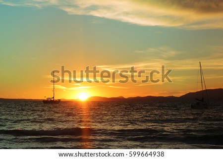Bright saturated sunset on the sea and a rocking boat on the waves