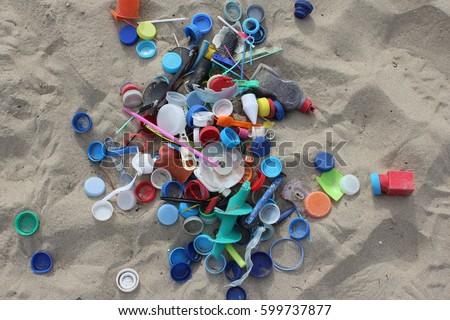 Plastic parts, found at the beach are collected and placed on the sand. 