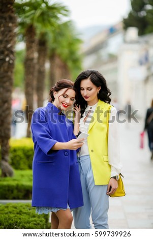 Young stylish, attractive women, stroll around the city, do selfie