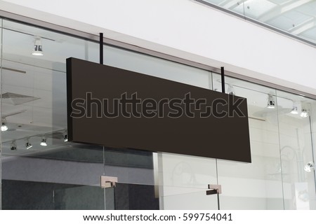 horizontal black empty signage on clothes shop front with glass windows  Royalty-Free Stock Photo #599754041