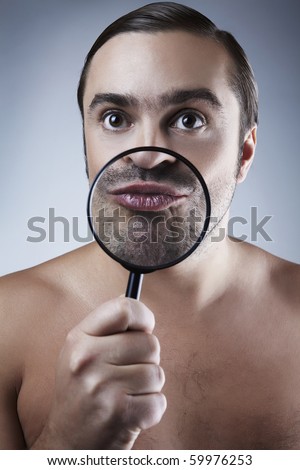 funny portrait of a adult man with a magnifying glass.