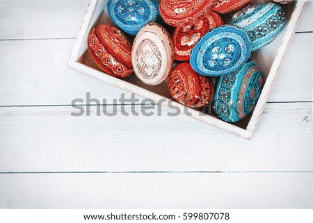 Easter eggs on wooden background with space. Colorful easter egg in the nest on wood background for text. Painted Easter eggs