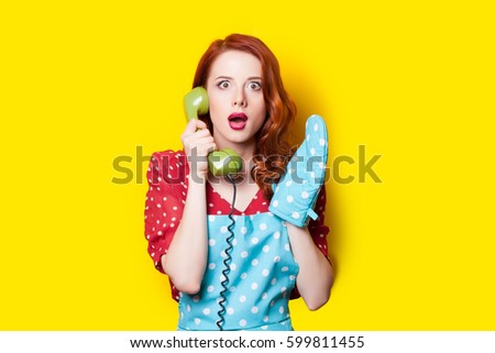 beautiful surprised young woman with retro phone and potholder on the wonderful yellow background