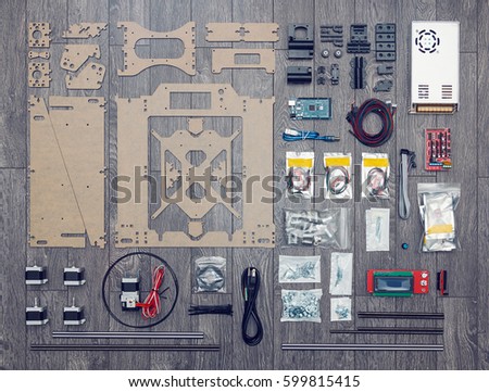 Flat lay of electronic and mechanical parts and components of DIY 3d printer on wooden surface
