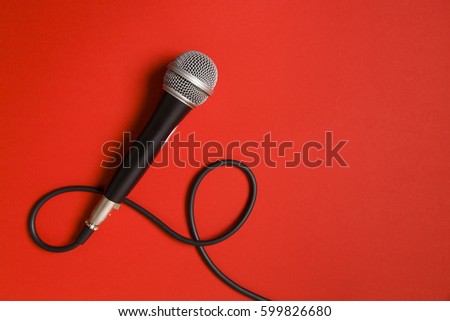 Vocal audio microphone on a bright red background Royalty-Free Stock Photo #599826680
