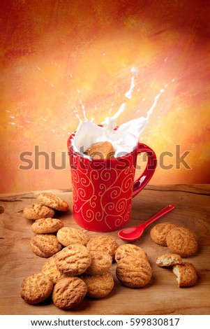 Delicious cookie falling into a cup of milk with big splash