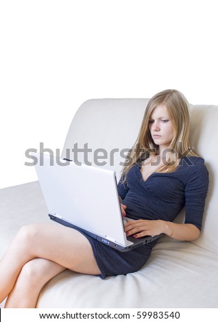Young girl with a serious face sitting on the couch and working on her notebook