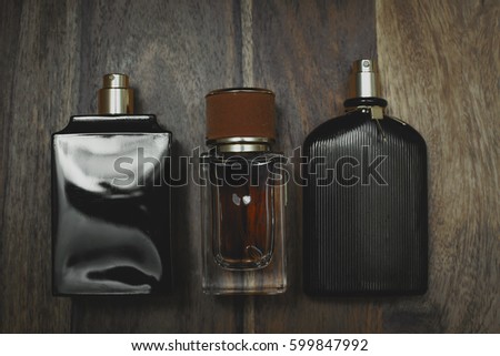 Different perfume bottles in wooden background