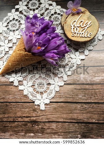 Rustic crocus. Spring day to smile. crocus in waffle cup on wooden lace background. Positive spring wallpaper 