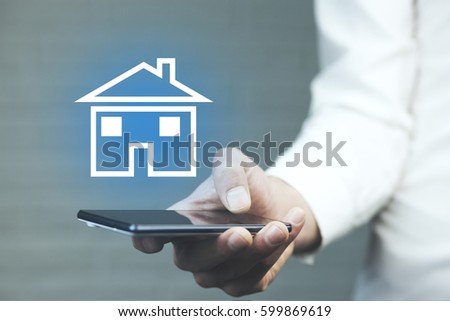 man hand phone with house in screen