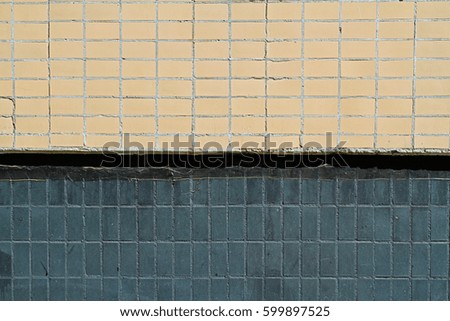 Mosaic tiles on the facade of a house. Architectural background made of beige and black mosaic wall
