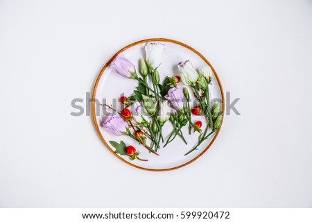 Lovely unique flower in circular clay plate on white background. Floral arrangement, flat lay styling. Top view. Creative still life idea of spring wallpaper. Nice and gorgeous scene. Beauty world.

