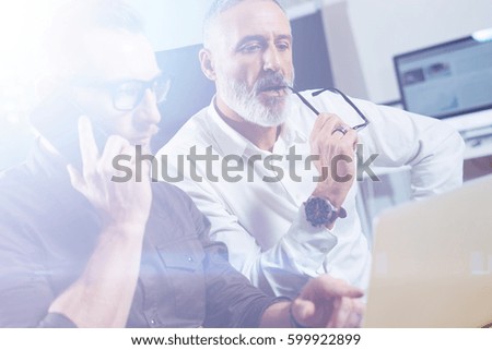 Group of two partners making conference call to discuss a new business idea in modern office.Young bearded businessman making call on smartphone.Business people meeting concept.Visual effects