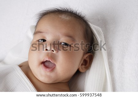 Head shot of Chinese baby smiling at camera.