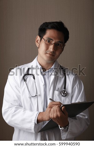 Male doctor holding clip board