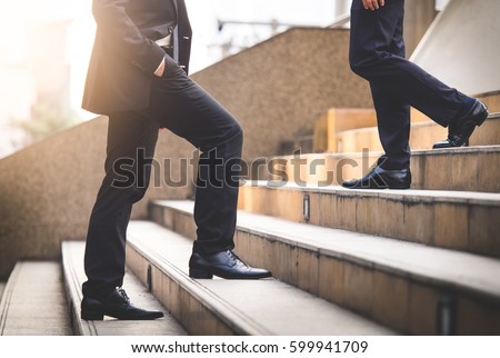 Close up legs of businessman walking stepping up stair in modern city, business growth, go up, success, grow up business concept Royalty-Free Stock Photo #599941709