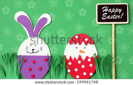 easter hand made greeting card: festive plastic foam bunny and egg with blackboard isolated on flower background with copy space