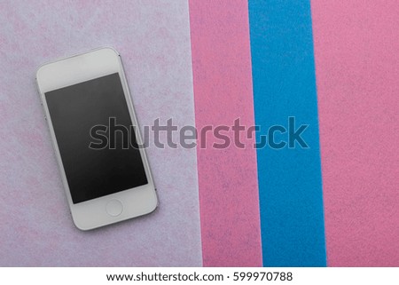 smart phone is lying on a pink background top view. 
modern technology, mobile communications