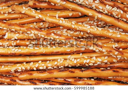 Breadsticks as background. Stick crackers pattern texture with sesasme seeds.