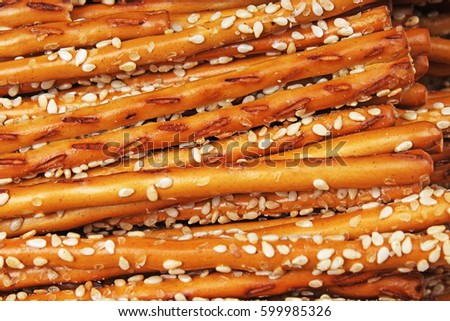 Breadsticks as background. Stick crackers pattern texture with sesasme seeds.
