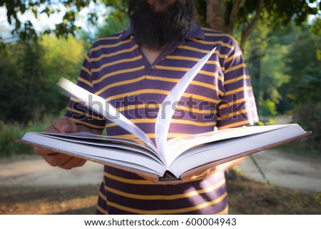 The man is holding a book open