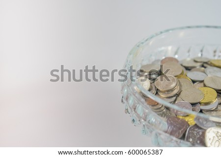 Soft focus of Malaysian coin in clear glass goblet on isolated background