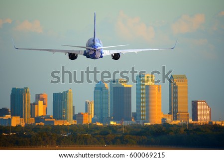 Tampa, Florida, skyline with warm sunset light with a commercial passenger jet airliner plane arriving or departing the International Airport.