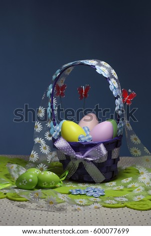 Easter eggs basket. Painted eggs. Easter background. Easter theme decoration. Colorful easter eggs on blue background.