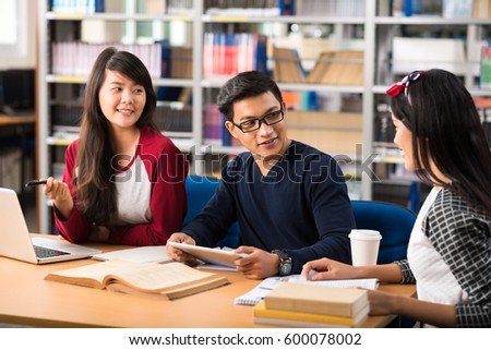 Vietnamese students discussing homework in library
