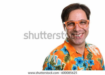 Studio shot of young happy Persian tourist man smiling while wearing orange eyeglasses isolated against white background