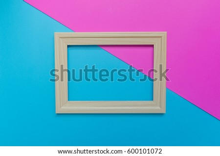 Wood photo frame on on pink and blue background. 