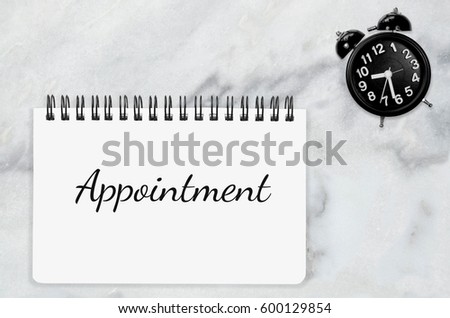 Appointment word annual checkup on white paper memo note. Annual dental check with black table clock on white marble desk office background Business Appointment