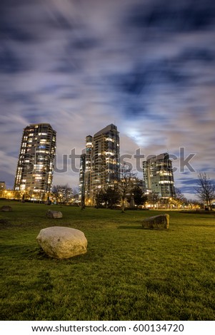 Night scene in George Wainborn Park with residential buildings in the background. Picture taken during a cloudy night with a full moon.