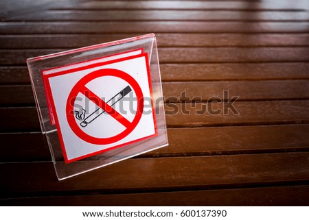 No smoking sign on the table. To remind you to smoke in this area. With the vignette light.