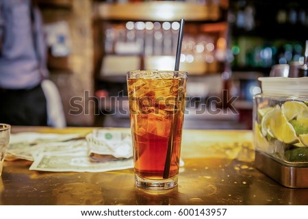A glass of coke and ice is served at the bar