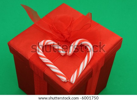 Candy canes in shape of a heart on red Christmas present