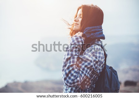 Girl travel in mountains alone. Spring weather, calm scene. Backpacker walking outdoors, view over landscape in sunlight. Wanderlust photo series.