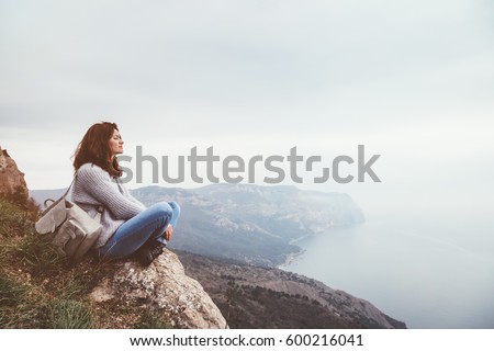 Girl travel in mountains alone. Spring weather, calm scene. Backpacker walking outdoors, back view over landscape. Wanderlust photo series. Royalty-Free Stock Photo #600216041
