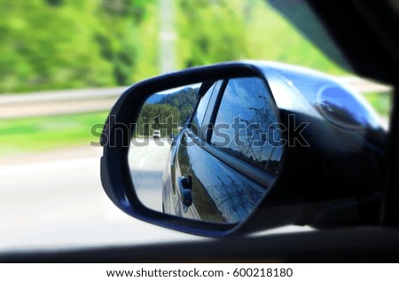 Car side mirror view with motion blur