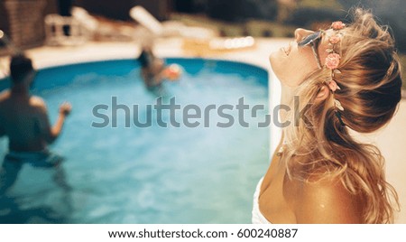 Beautiful blond  woman enjoying summer at swimming pool