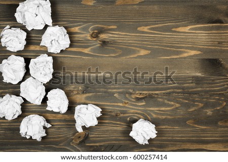Crumpled paper on wooden background.