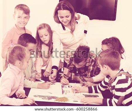 Portrait positive team of elementary age children  drawing on one sheet
